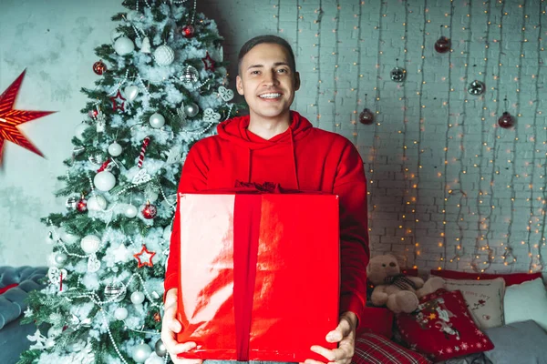 Jonge Knappe Man Met Groot Verpakt Geschenk Achtergrond Van Kerstboom — Stockfoto