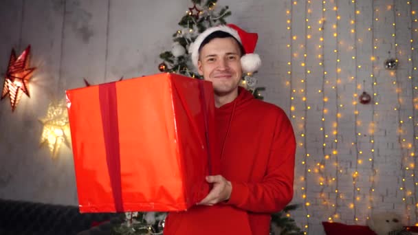 Noel Baba Şapkalı Genç Yakışıklı Adam Noel Ağacının Arkasında Büyük — Stok video