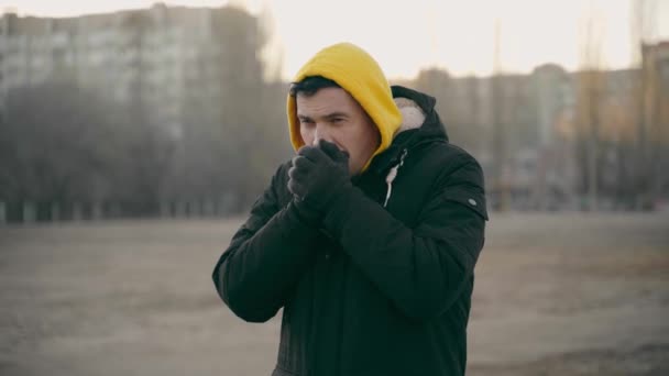 Fiatal Fagyott Férfi Sárga Csuklyában Fekete Kabátban Felnőtt Férfi Melegítő — Stock videók