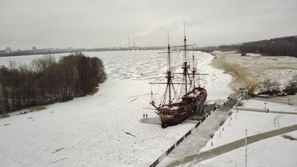 Letecký pohled na bitevní loď námořnictva v zimní sezóně. Pohled z ptačí perspektivy na historickou loď na ledě v zimě. — Stock video
