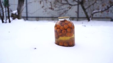 Meyve ve meyveli konserve meyve suyunu sokakta kapayın. Bahçe bahçesinde kışın mühürlü gübre kavanozları.