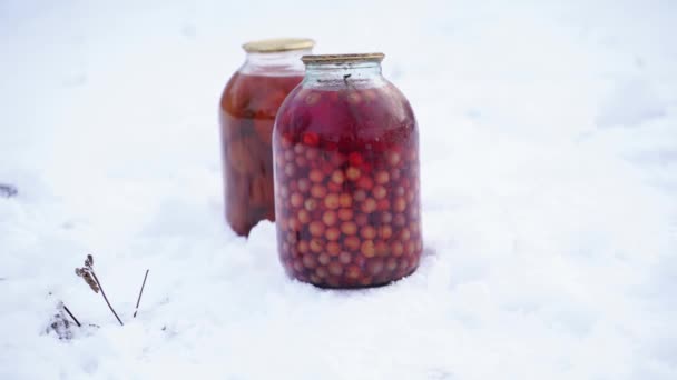 通りの雪の中でベリーとトマトと缶ジュースの閉じます 冬の庭での堆肥の密封瓶 — ストック動画