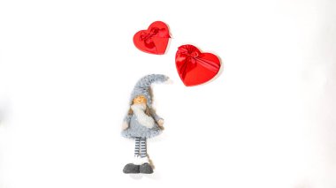 Yalıtılmış beyaz arka planda kalp şeklinde hediye kutularıyla sevimli oyuncak bebekleri kapatın. Tatil kavramı, hediyeler ve iyi ruh hali.