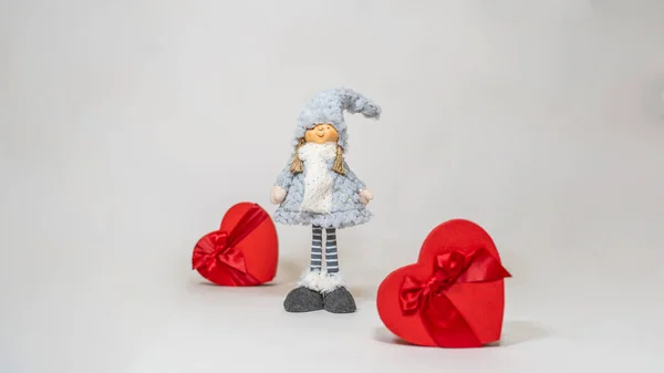 在孤零零的白色背景上 用心形的礼品盒紧紧地抱着可爱的娃娃 送礼和心情好的概念 — 图库照片