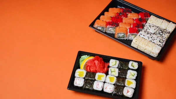 Primo Piano Sushi Appetitoso Contenitori Sfondo Arancione Set Gustosi Involtini — Foto Stock