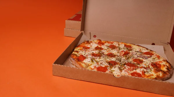 Zamknij Dużą Pizzę Pudełku Pomarańczowym Tle Apetyczna Pizza Różnymi Składnikami — Zdjęcie stockowe
