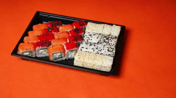Primer Plano Sushi Apetitoso Recipiente Sobre Fondo Naranja Set Sabrosos —  Fotos de Stock