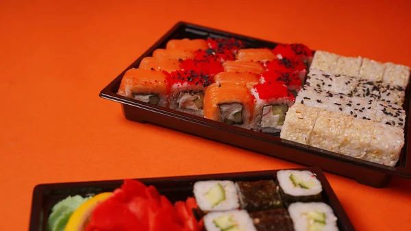 Primer Plano Sushi Apetitoso Recipientes Sobre Fondo Naranja Set Sabrosos —  Fotos de Stock