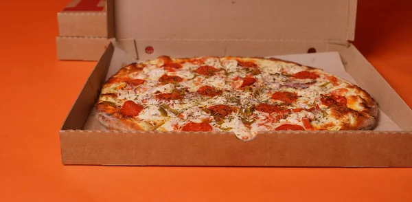 Zamknij Dużą Pizzę Pudełku Pomarańczowym Tle Apetyczna Pizza Różnymi Składnikami — Zdjęcie stockowe