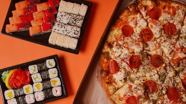 Zblízka Chutné Sushi Kontejnerech Velká Pizza Krabici Oranžovém Pozadí Pizza — Stock fotografie