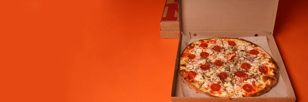 Zamknij Dużą Pizzę Pudełku Pomarańczowym Tle Apetyczna Pizza Różnymi Składnikami — Zdjęcie stockowe