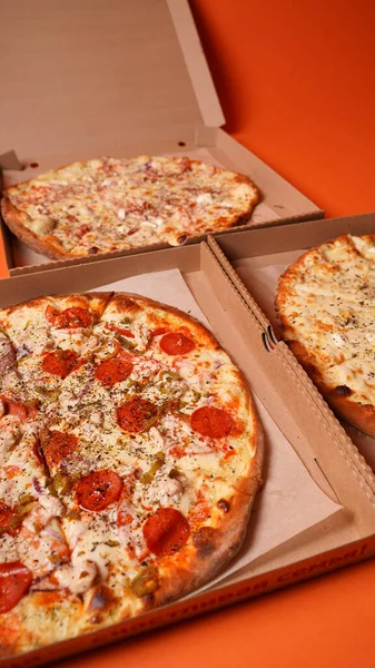 Zamknij Duże Pizze Pudełku Pomarańczowym Tle Apetyczne Pizze Różnymi Składnikami — Zdjęcie stockowe