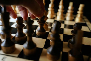 Siyah arka planda satranca yakın çekim. Tahta satranç taşları. Kavram: Masa oyunu ve entellektüel faaliyetler.