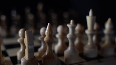 Siyah arka planda satranca yakın çekim. Tahta satranç taşları. Kavram: Masa oyunu ve entellektüel faaliyetler