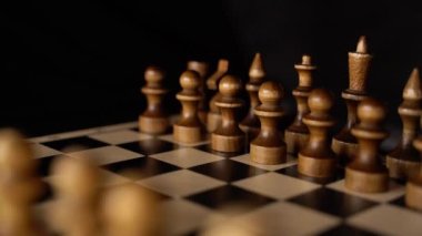 Siyah arka planda satranca yakın çekim. Tahta satranç taşları. Kavram: Masa oyunu ve entellektüel faaliyetler