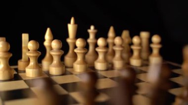 Siyah arka planda satranca yakın çekim. Tahta satranç taşları. Kavram: Masa oyunu ve entellektüel faaliyetler