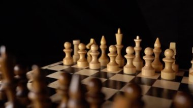 Siyah arka planda satranca yakın çekim. Tahta satranç taşları. Kavram: Masa oyunu ve entellektüel faaliyetler