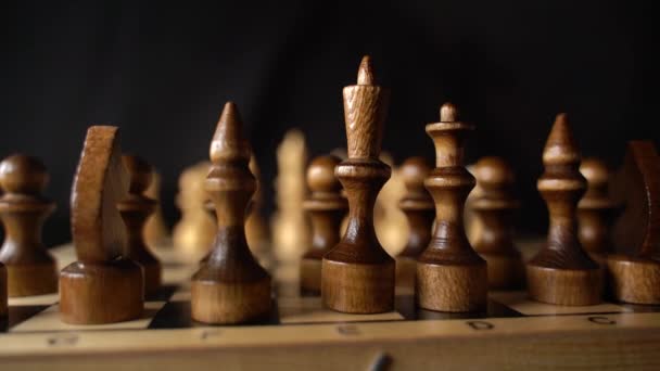Zavřít dvě řady bílých šachových figurín na šachovnici. Ženská ruka přesouvá dřevěné figurky z šachovnice na černém pozadí. Zpomalený pohyb. — Stock video