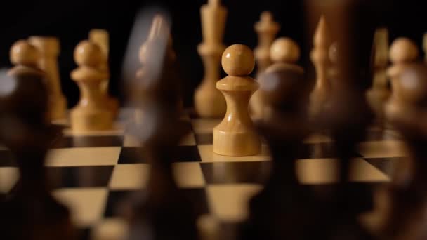 棋盘上的白色和黑色木制棋子 棋盘在黑色背景的比赛中设置的棋盘 — 图库视频影像