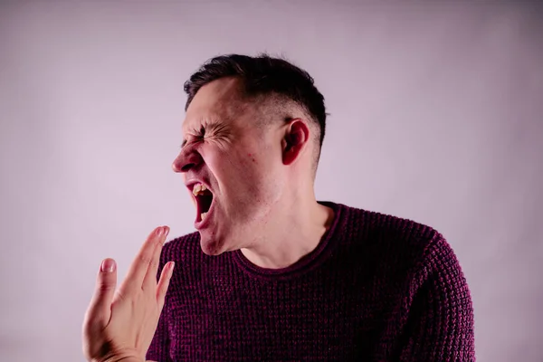 Crop person slapping scared man in face. Emotional male getting slapped in face while shouting with closed eyes in fear on white background.