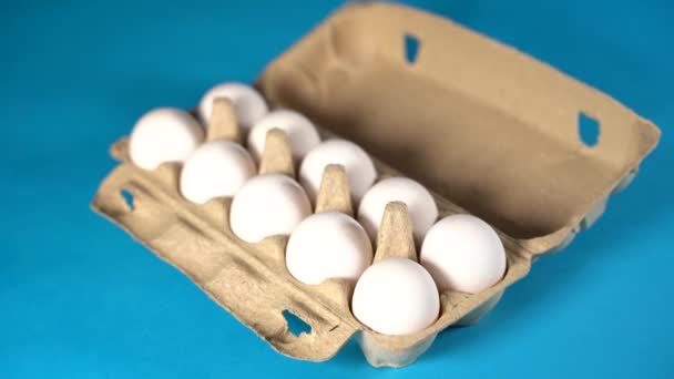 Ladang mentah, telur ayam putih segar dalam kotak telur dengan latar belakang biru. Telur di karton. Telur di keranjang. Konsep: telur segar untuk sarapan pagi. — Stok Video