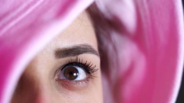 Kadın yüzünü kaputun arkasına gizliyor. Kapüşonlu poz veren şık bir kadın. Kapüşonlu genç bir kadının portresi.