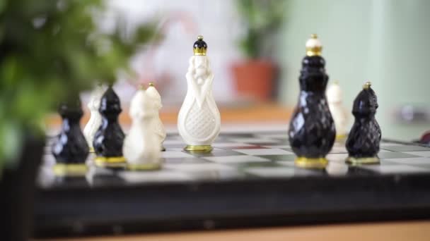キッチンのテーブルの上で美しいチェスを閉じます チェスボード上の磁器のチェスの駒の選択的な焦点 — ストック動画