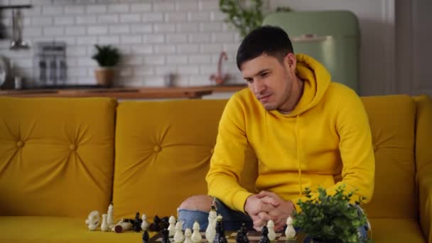 Mladý Muž Sedí Žluté Pohovce Hraje Šachy Místnosti Muž Hraje — Stock video