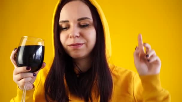 Розслаблена Молода Жінка Позує Склянкою Червоного Вина Жовтому Тлі Доросла — стокове відео