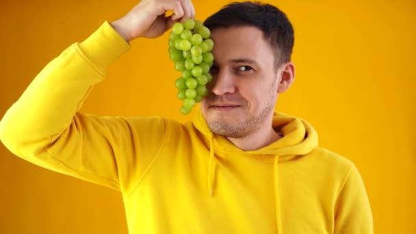 Retrato Joven Con Uvas Verdes Sobre Fondo Amarillo Primer Plano — Vídeo de stock