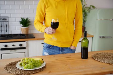 Kırmızı şarap kadehiyle tanınmayan bir adamı yakından çek. Mutfakta alkollü, kimliği belirsiz bir adamın cesedi..