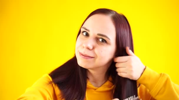 Sarı Arka Planda Saçını Tarayan Genç Bir Kadının Portresi Sarı — Stok video