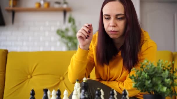 Jovem Mulher Sentada Sofá Amarelo Jogando Xadrez Quarto Feminino Jogando — Vídeo de Stock