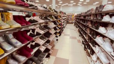 Ayakkabı mağazası, farklı ayakkabıları olan raf ünitesi. Ayakkabılar mağazada satışta