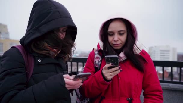 Zbliżenie Młodych Kobiet Przeglądających Smartfony Parku Miejskim Ładne Kobiety Kapturach — Wideo stockowe