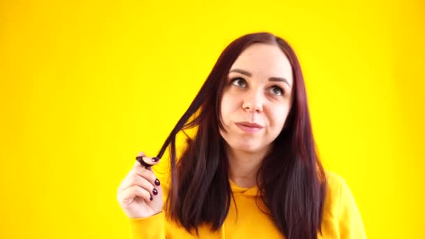 Κοντινό Πλάνο Της Νεαρής Γυναίκας Περιστρέφει Μαλλιά Της Κίτρινο Φόντο — Αρχείο Βίντεο