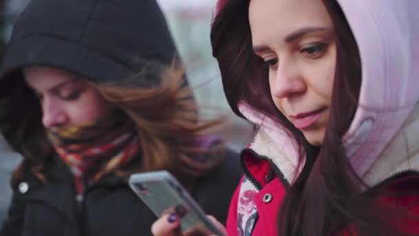 Zbliżenie Młodych Kobiet Przeglądających Smartfony Parku Miejskim Ładne Kobiety Kapturach — Wideo stockowe
