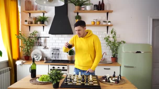 Unge Man Dansar Dricker Rödvin Och Spelar Schack Köket Glad — Stockvideo