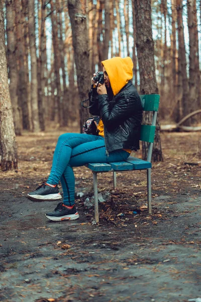 Молодая Женщина Повседневной Одежде Сидит Скамейке Фотографирует Старую Фотокамеру Лесу — стоковое фото