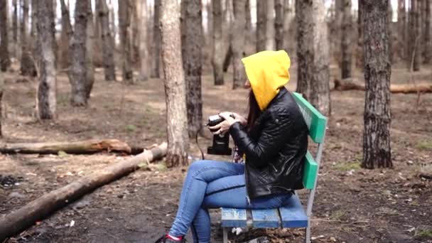 Ung Kvinna Avslappnade Kläder Sitter Bänken Och Fotograferar Gamla Fotokamera — Stockvideo