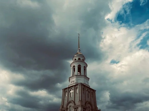 Bell tower of the cathedral of Christ. The bell tower of a Christian church on the background of a cloudy sky.