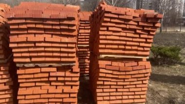 Şehir caddesinde kırmızı tuğlalı palet yığını. İnşaat alanındaki inşaat malzemeleri. Binalar inşa etme kavramı