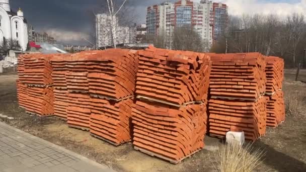 Högen Med Pallar Med Röda Tegelstenar Stadens Gata Byggnadsmaterial Byggarbetsplatsen — Stockvideo