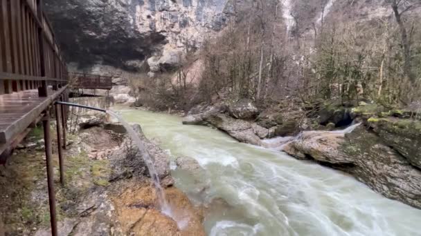 Eau de pluie qui coule du drain à la rivière de montagne. L'eau de pluie coule de la trombe descendante sur fond de paysage montagneux. — Video