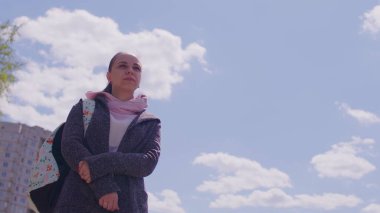 Güneşli bir havada genç bir bayana yakın durun. Sırt çantalı, temiz hava almış kadın portresi.