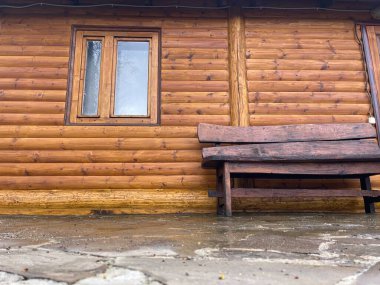 Ahşap evin yanındaki ahşap bankın yanına. Açık hava eğlencesi için ahşap sıra