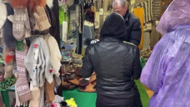 Guamka, Rusya 17 Nisan 2021: Yağmurlu havada pazarda turistleri kapatın. Bir grup insan alışveriş kabinlerinde hediyelik eşya almayı düşünüyor..