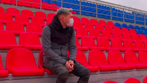 Jovem Mascarado Sentado Sozinho Nas Bancadas Estádio Homem Adulto Triste — Vídeo de Stock