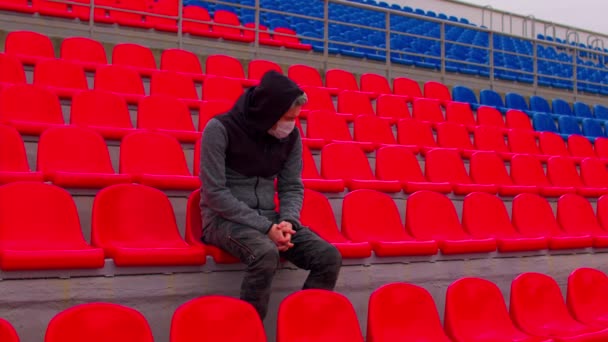 Jovem Mascarado Sentado Sozinho Nas Bancadas Estádio Homem Adulto Triste — Vídeo de Stock