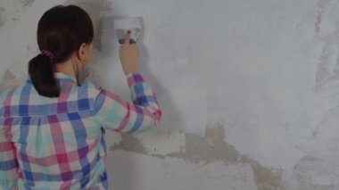 Bir kadın evinde tamirat yaparken duvara macun yapıştırıyor. Çalışma süreci, kadın işçi macun çözeltisi koyuyor. Kendi ellerinle onar. Metin için yer